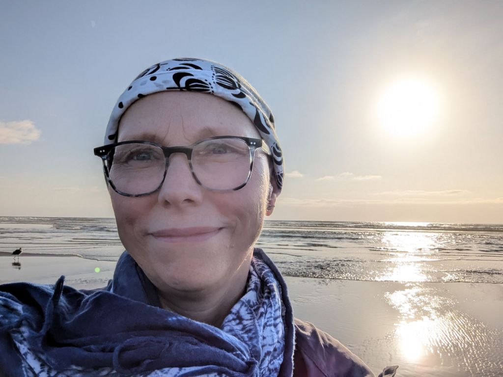 Portrait of a middle aged woman in her 40s on a beach at sunset