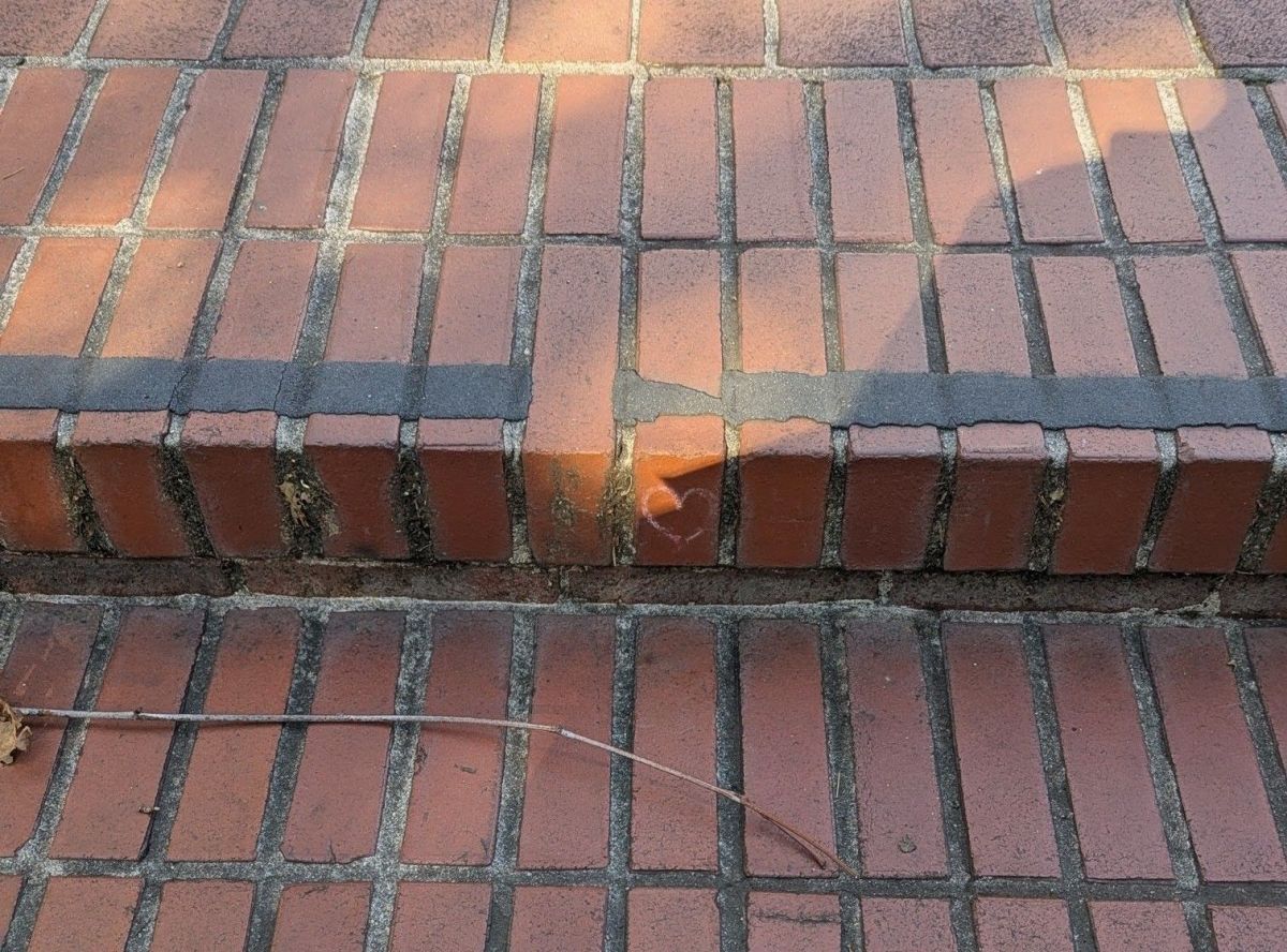 Small heart drawn on brick steps. Branch on step below.
